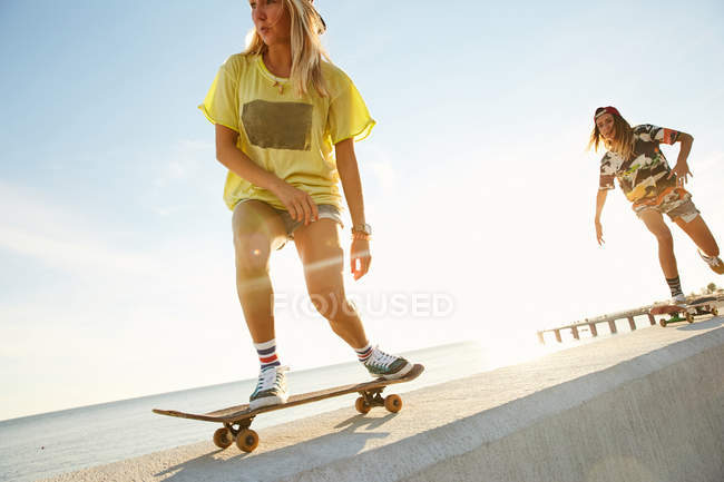Donne che cavalcano su skateboard — Foto stock