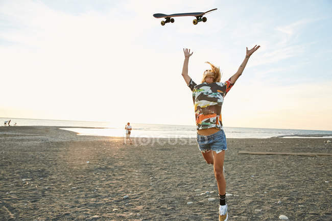 Женщина бросает скейтборд — стоковое фото