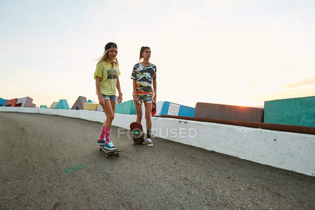 Mulheres com skates no estacionamento — Fotografia de Stock