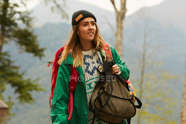 Woman in green jacket with backpack — Stock Photo
