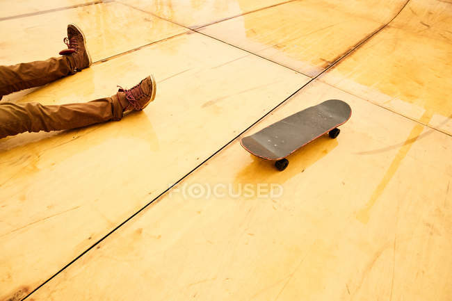 Скейтер сидить з дошкою на рампі — стокове фото