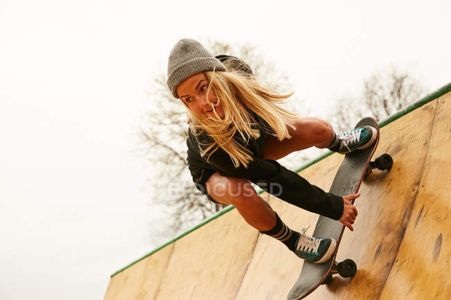 Junge Frau skatet auf Rampe — Stockfoto