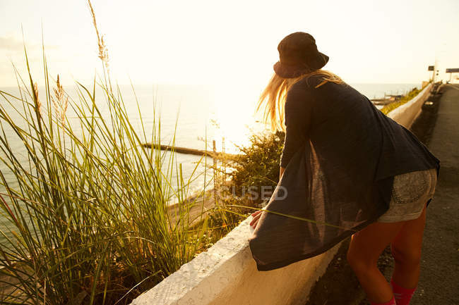Девушка наблюдает за водой на границе на берегу моря — стоковое фото