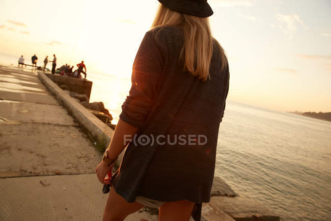 Chica caminando en primera línea de mar - foto de stock