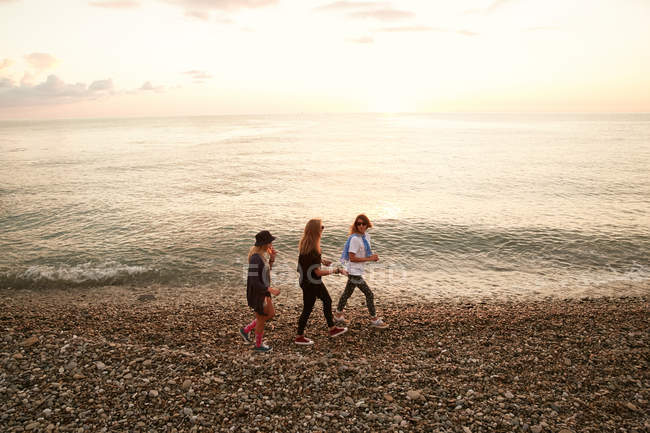 Girls walking on rocky beach — Stock Photo