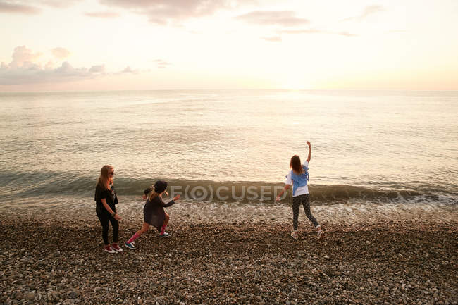 Amigos jogando pedras na água — Fotografia de Stock