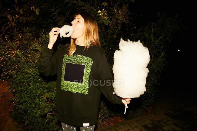 Girl eating cotton candy — Stock Photo