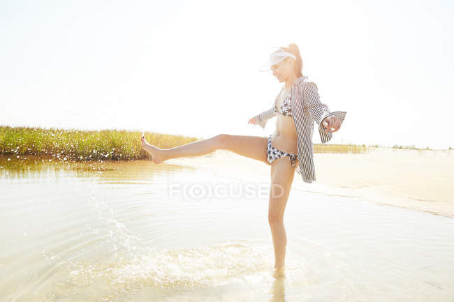 Femme en visière s'amuser sur la plage — Photo de stock