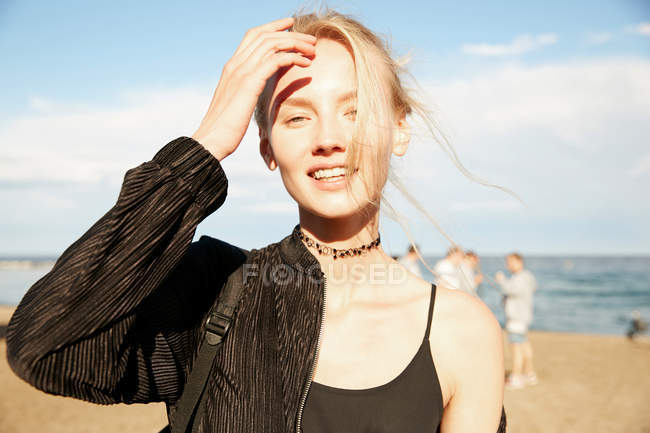 Portrait of smiling woman looking at camera on beach in barcelona — Stock Photo