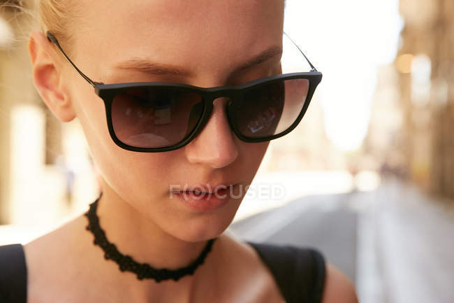 Retrato de jovem mulher em óculos de sol andando na rua em barcelona — Fotografia de Stock