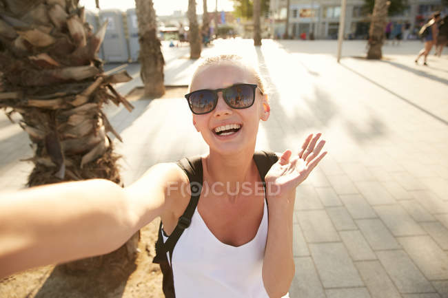 Camera point of view of blonde young tourist with black bag standing on street in barcelona — Stock Photo