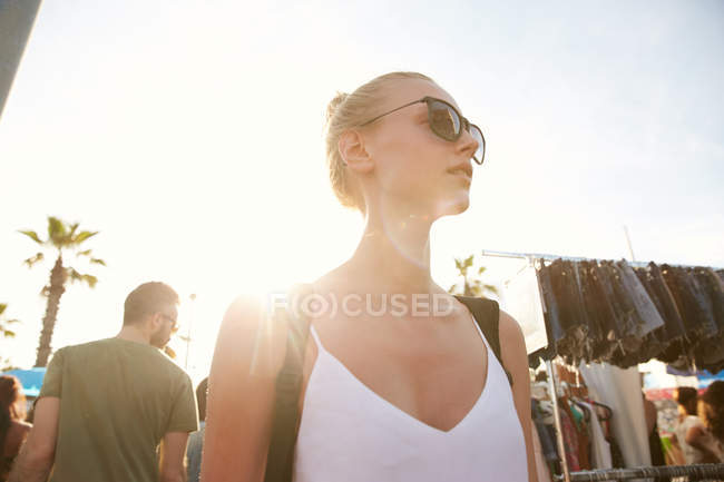 Low angle view of woman in sunglasses standing at street market in barcelona — Stock Photo