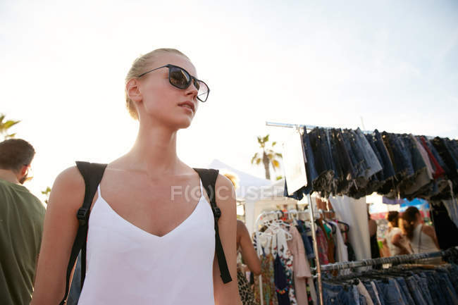 Low angle view of woman in sunglasses standing at street market in barcelona — Stock Photo