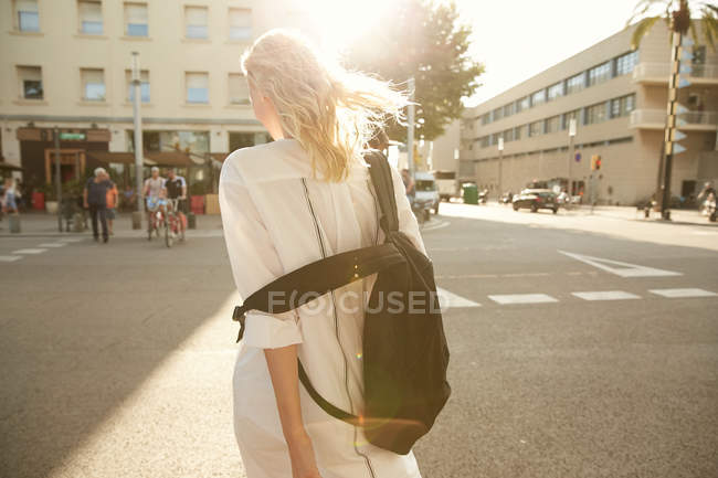 Вид ззаду жінки, що йде з мішком на вулиці в Барселоні — стокове фото