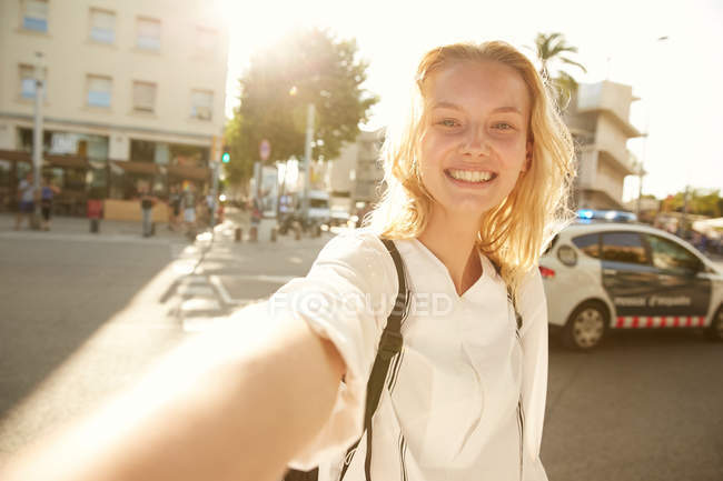 Camera point of view of smiling woman walking with bag on street in barcelona — Stock Photo