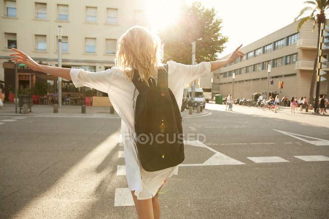 Visão traseira da mulher andando de braços abertos na rua em barcelona — Fotografia de Stock