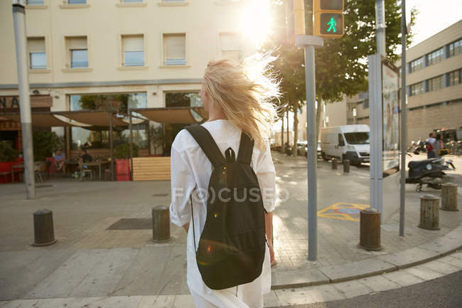 Vista trasera del viajero caminando con bolsa en calle en barcelona - foto de stock