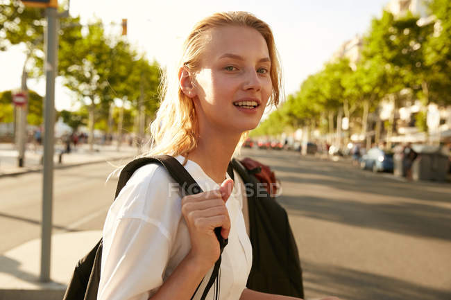 Cheerful woman walking with bag on street in barcelona — Stock Photo
