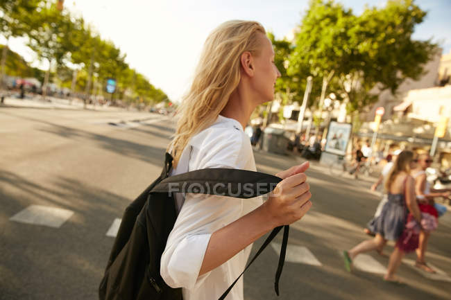 Вид збоку молоду жінку, прогулянки з мішок на вулиці в Барселоні — стокове фото