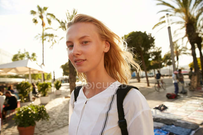 Retrato de mujer caminando con el bolso en la calle y mirando la cámara en barcelona - foto de stock