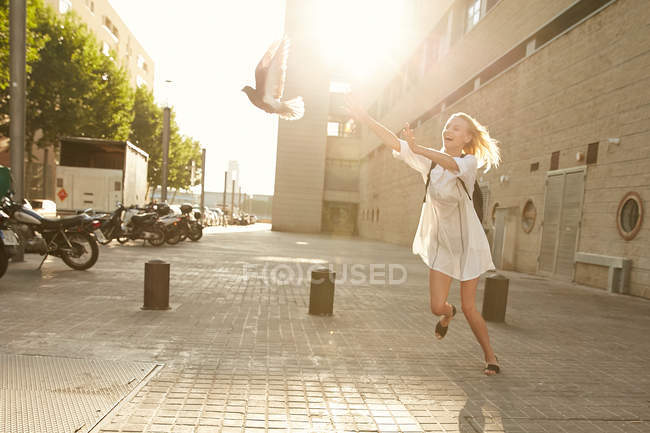 Donna felice cattura piccione sulla strada a Barcellona — Foto stock