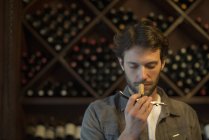 Sommelier sniffing wine cork in wine shop — Stock Photo
