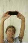 Frau macht Selfie auf dem Smartphone im Bett — Stockfoto