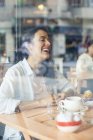 Сміється жінка в кав'ярні — стокове фото