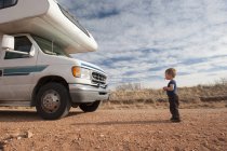 Toddler standing in front of motor home — Stock Photo
