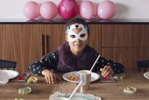 Menina usando máscara festiva na festa de aniversário — Fotografia de Stock
