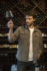 Weinkenner hält Glas Wein in die Höhe — Stockfoto