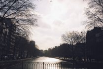 Scène de canal tranquille avec la ville — Photo de stock