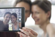 Pareja usando tableta digital para tomar una selfie - foto de stock