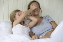 Madre e hija uniéndose en la cama - foto de stock