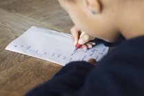 Girl writing in cursive on paper, cropped — Stock Photo