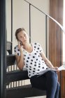 Женщина по телефону сидит на лестнице — стоковое фото