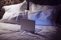 Laptop computer on bed — Stock Photo