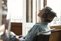 Mulher relaxante enquanto ouve música — Fotografia de Stock