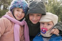 Молодые братья и сестры, одетые в зимнюю одежду, портрет — стоковое фото