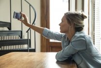 Mujer tomando selfie con smartphone - foto de stock