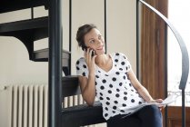 Donna che prende il cellulare seduto sulle scale — Foto stock