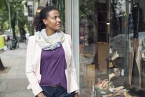 Afro-americana mulher olhando para loja janela — Fotografia de Stock