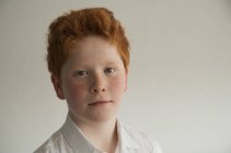 Retrato de menino com cabelos vermelhos e sardas contra fundo cinza — Fotografia de Stock