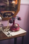 Крупным планом красный антикварный телефон на столе — стоковое фото