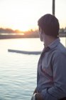 Портрет человека, смотрящего на закат на озере — стоковое фото