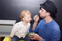 Батько годує дитяче морозиво ложкою — стокове фото
