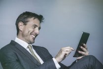 Чоловік сміється під час використання цифрового планшета — стокове фото