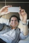 Homem usando smartphone para tirar uma selfie — Fotografia de Stock