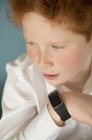 Porträt eines Jungen, der in die Smartwatch spricht — Stockfoto