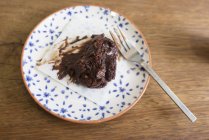 Vista aérea da peça Bolo de chocolate no prato com garfo — Fotografia de Stock